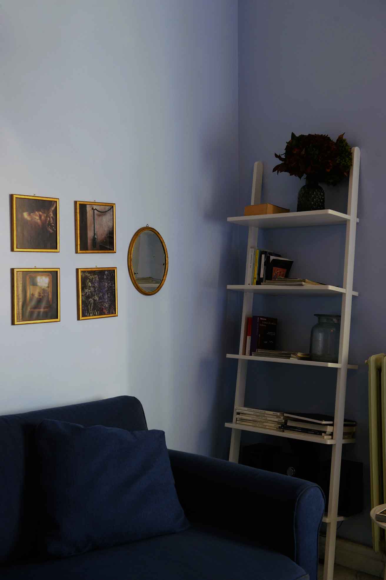 [Appartamenti] Dettaglio camera, quadri, specchio e libreria. [Appartamenti] Room detail, paintings, mirror, and bookshelf.