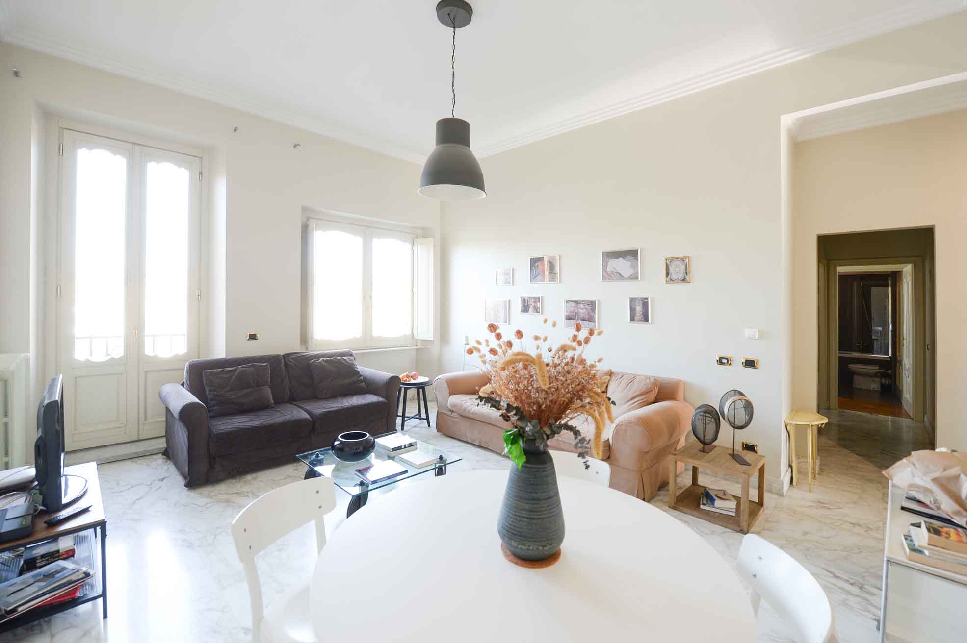 [Appartamenti] Tra una passeggiata e l'altra nel centro di Roma una buona idea è rilassarsi nel soggiorno a due divani da cui accedere al balcone con affaccio sul Tevere e Ara Pacis. [Appartamenti] Between strolls in the center of Rome, a great idea is to relax in the living room with two sofas, from which you can access the balcony with a view of the Tiber and Ara Pacis.